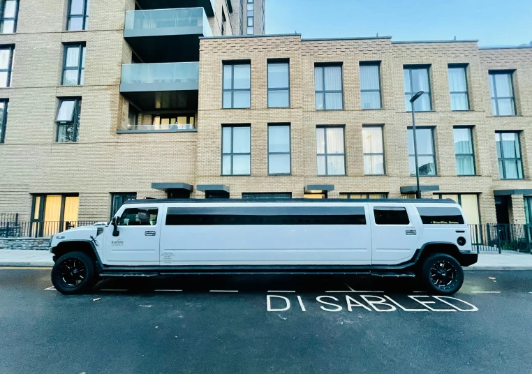 a white hummer is parked near a building