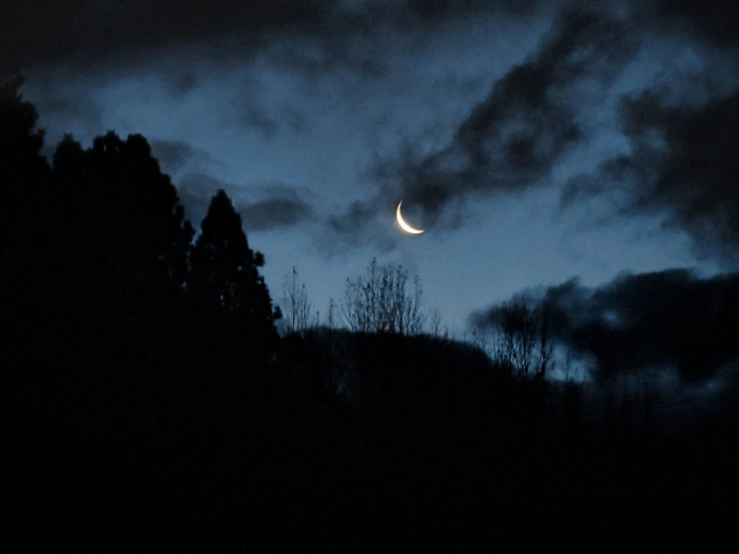 a sky scene with clouds and a half moon