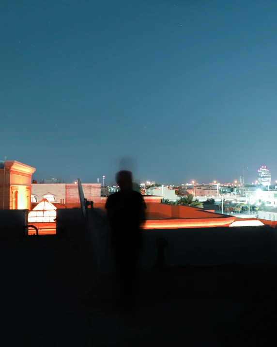a man standing on top of a rooftop at night