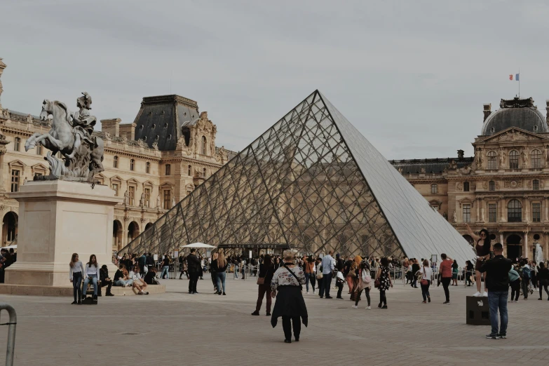 some people are walking around in front of a pyramid