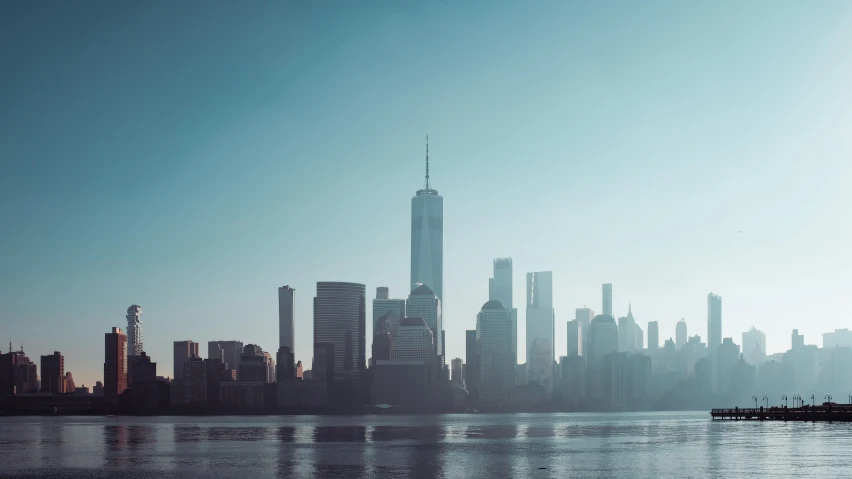 a city skyline on a river that has very tall buildings