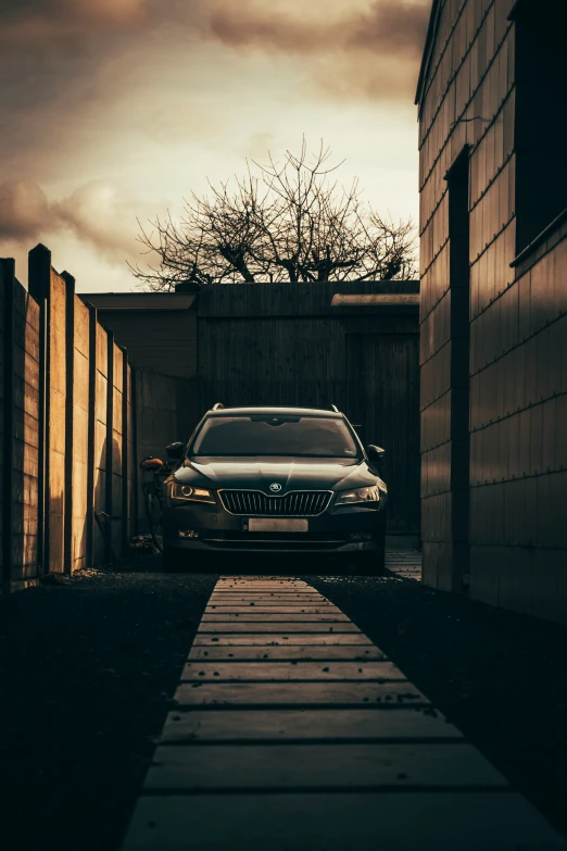 there is a very large silver car parked at the end of a walkway