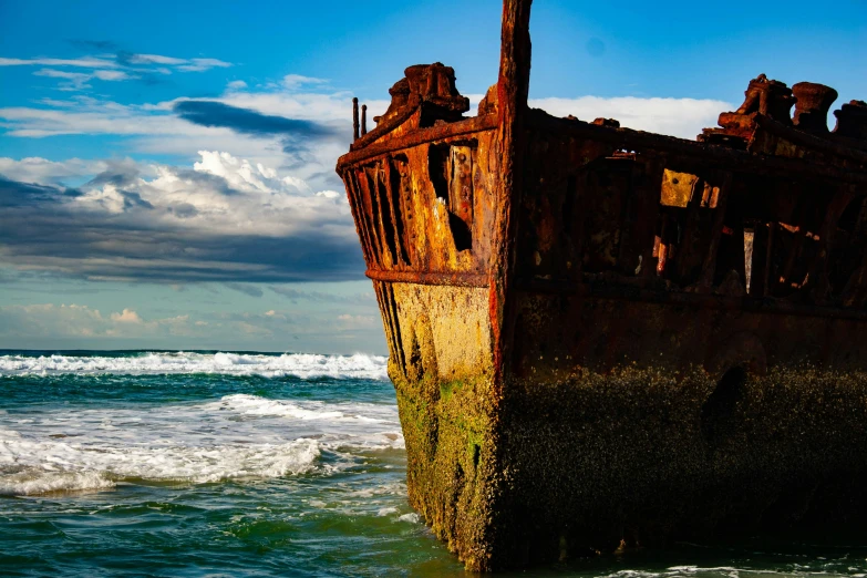 a rusty old ship sitting in the ocean