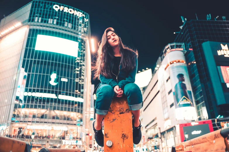 girl with skateboard in the city at night