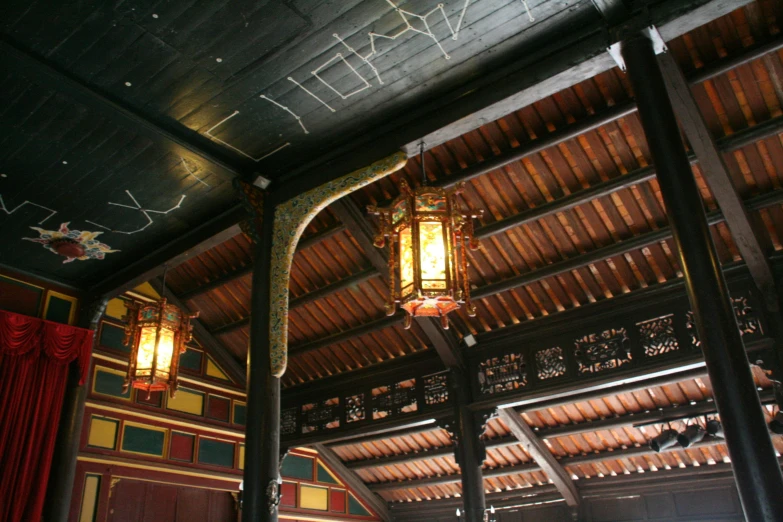the old wooden ceiling has two lamps and decorations