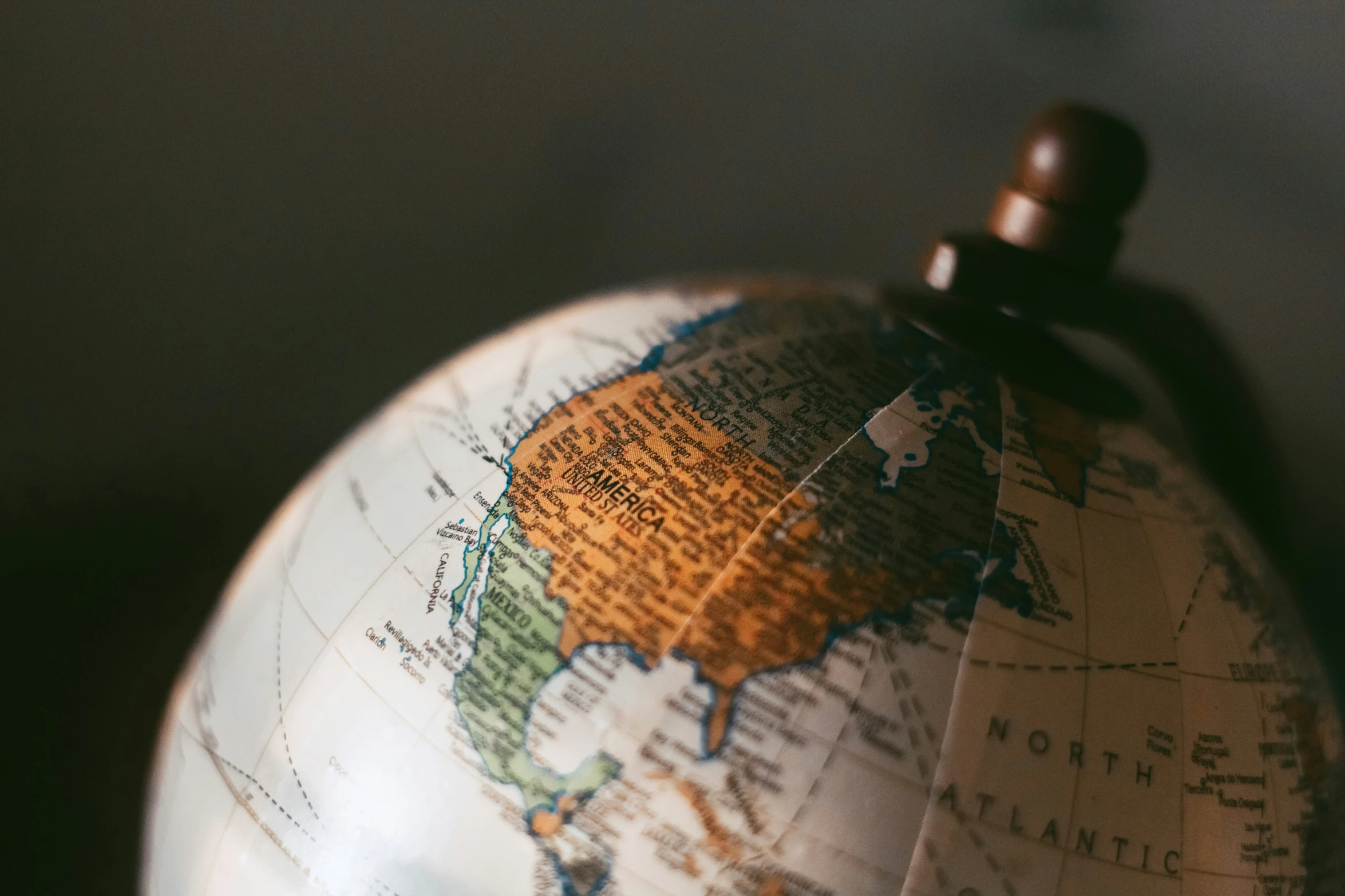 an antique globe with wood stand on a table