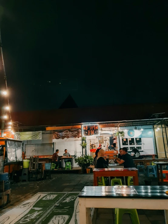 a small patio with tables on either side and chairs at the end