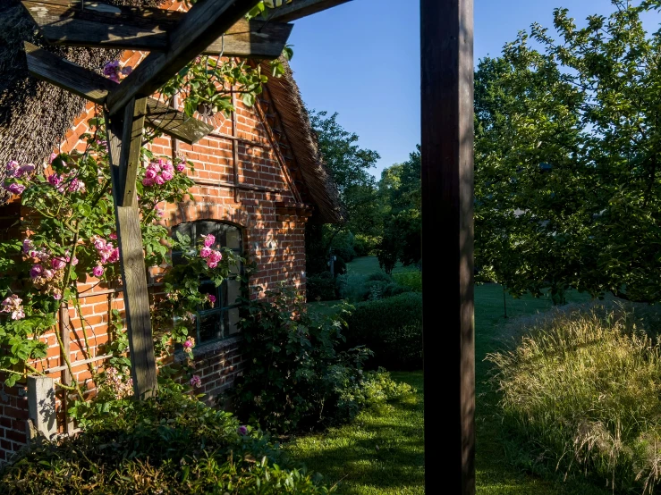 a small brick house surrounded by lush green trees