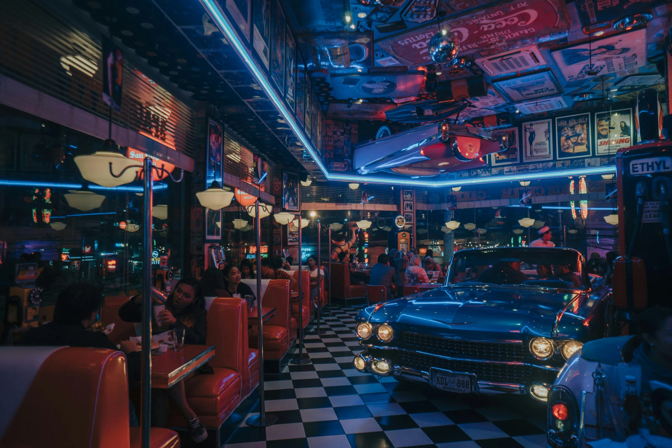 an interior view of a diner with people in seats and parked cars