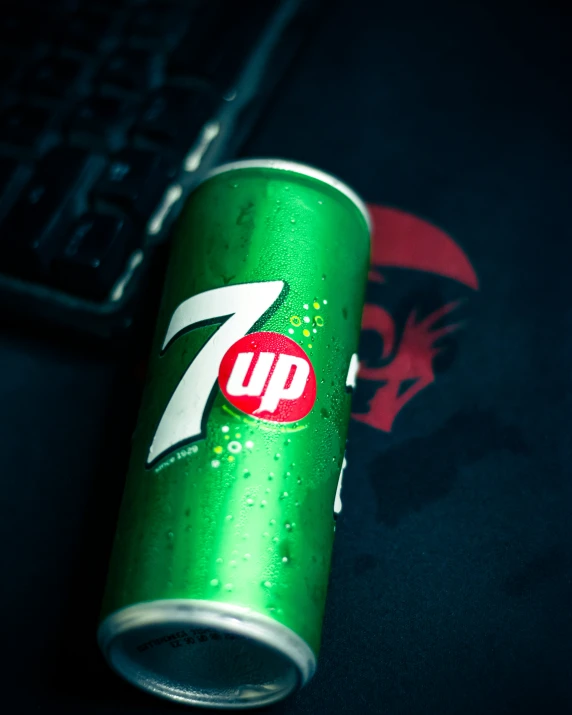 green can of 7 up on a black surface