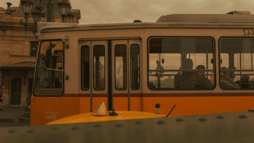 a white and orange train traveling down the street