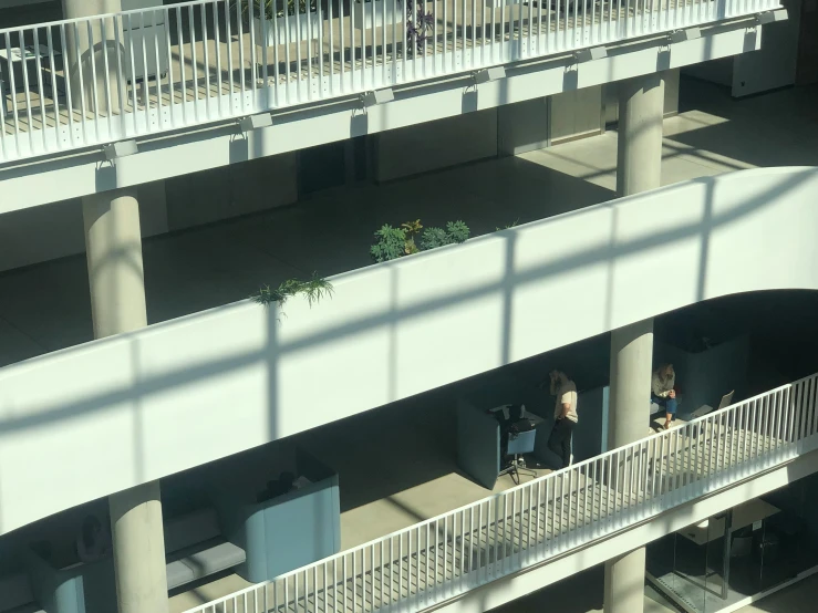 several people stand in an open atrium on their cell phones