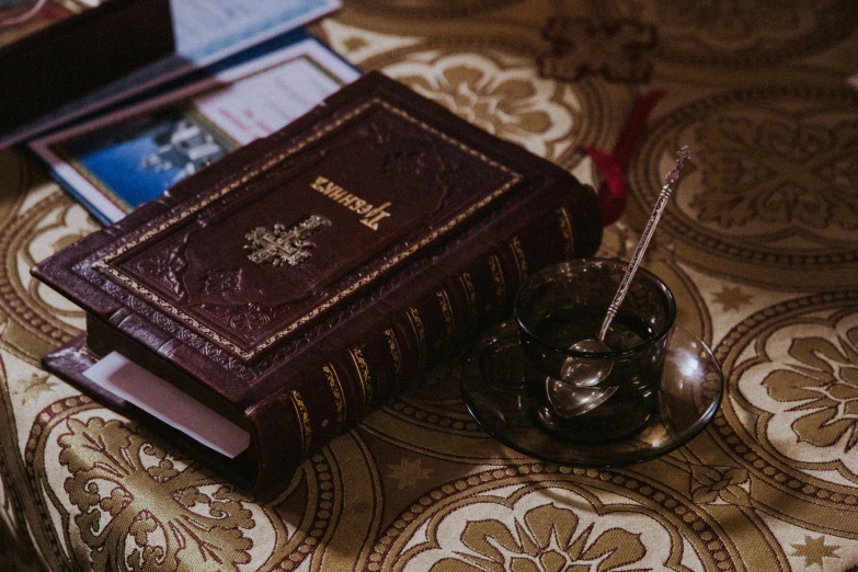 a small metal spoon resting next to a large, old book