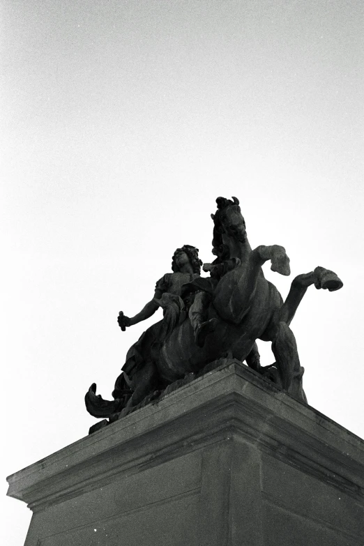 statue of two men riding a horse and a horse on a pedestal
