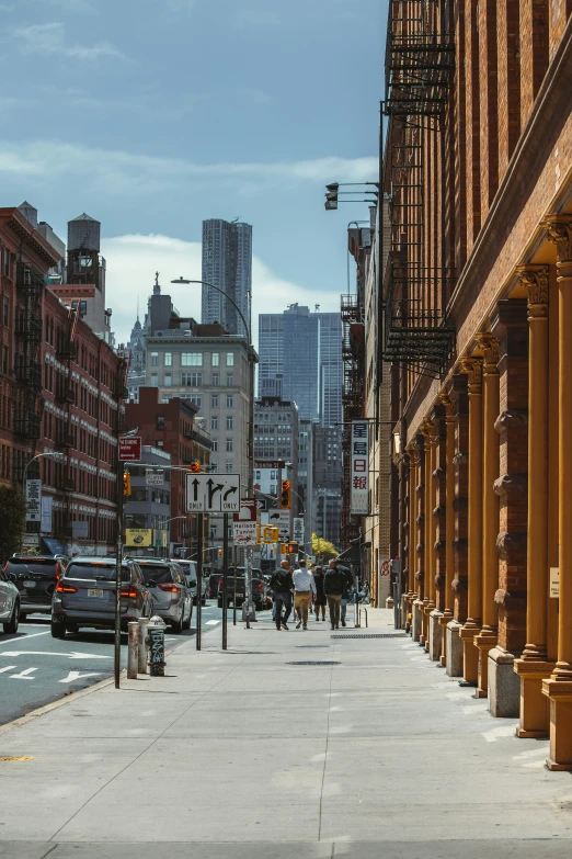 street signs line the sides of large buildings and an empty sidewalk