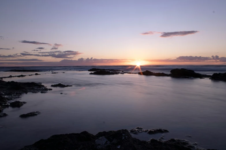 the sun setting over the ocean in the background