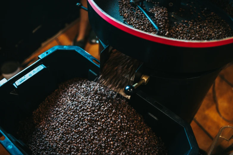 a red coffee maker filled with freshly roasted coffee beans