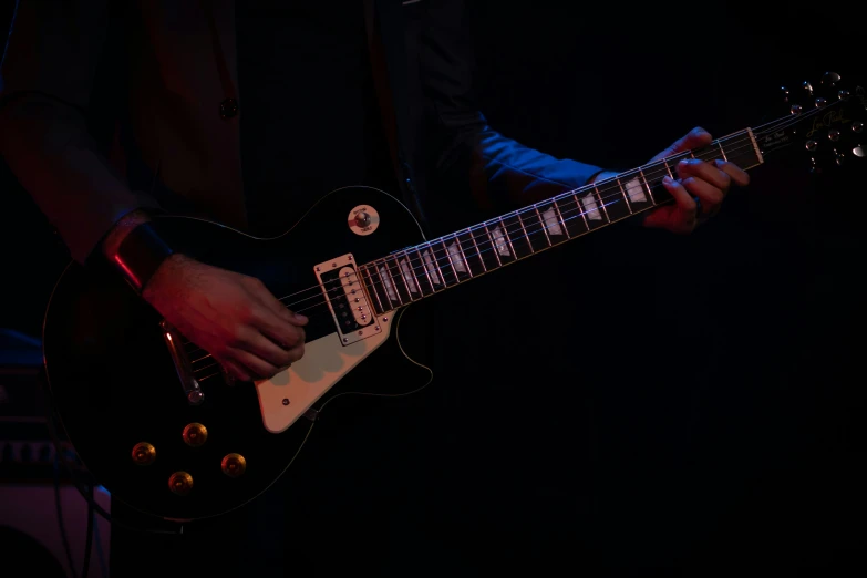 a man playing a guitar in a dark room