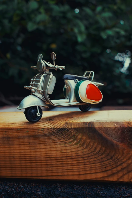 a metal scooter is on a wooden surface