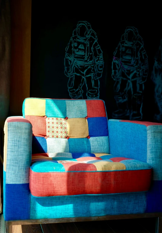 a sofa covered in quilts is shown against a chalk board