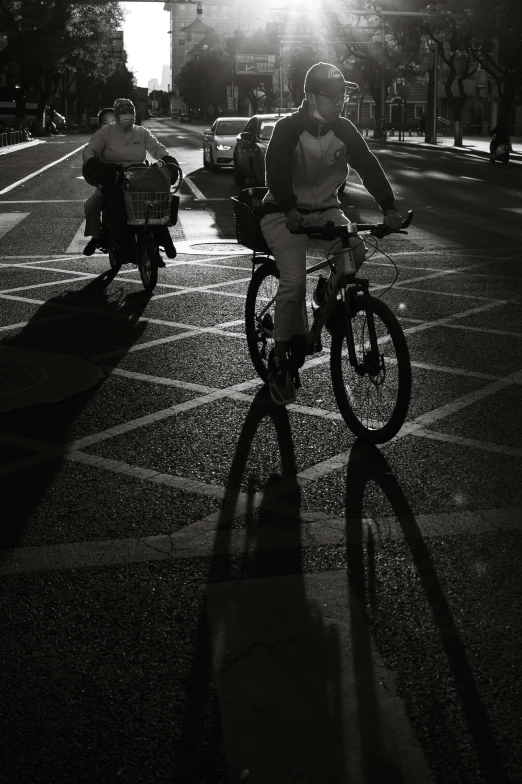 two people are riding bicycles at night on the street