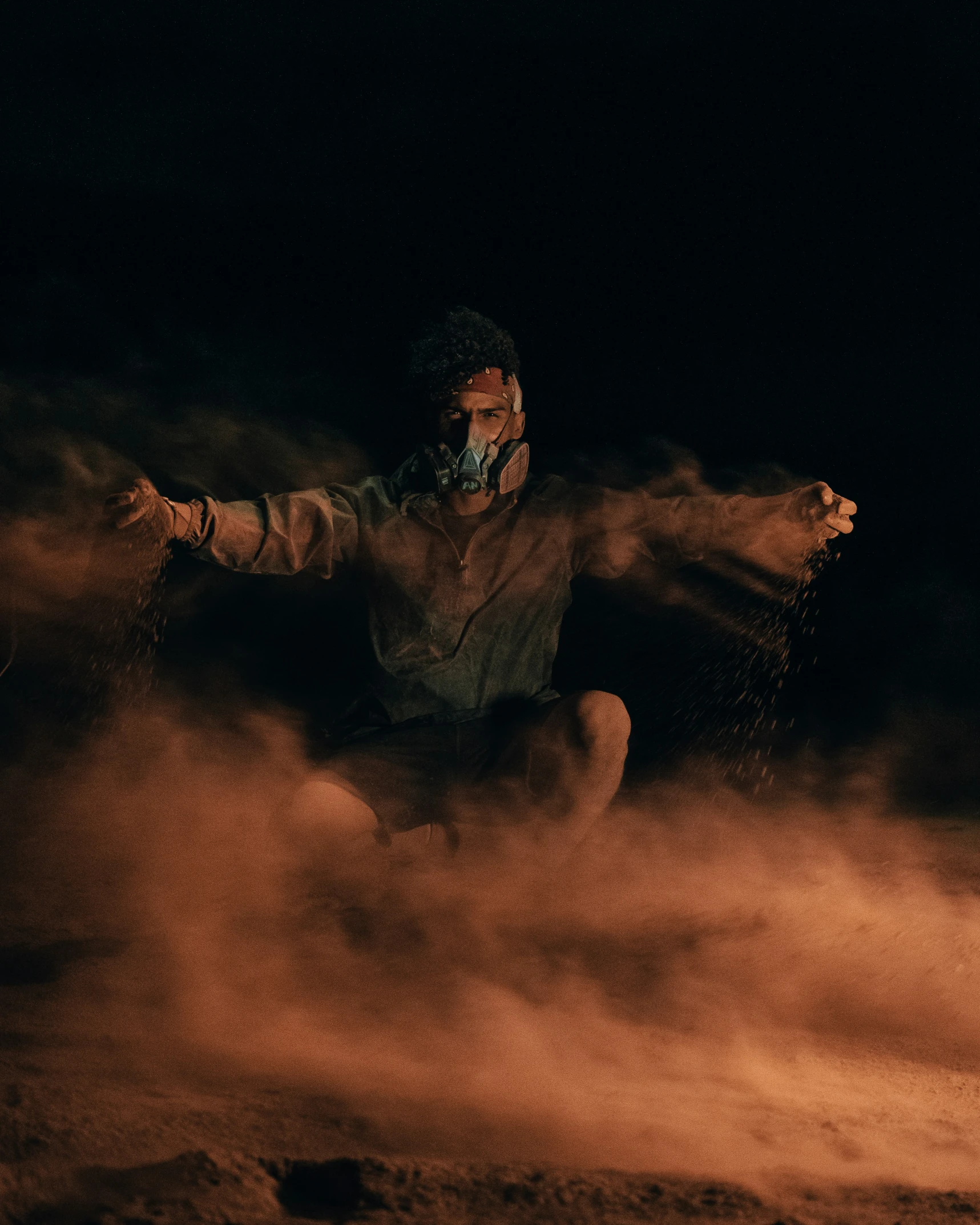 a man in white jacket sitting on the ground surrounded by fog