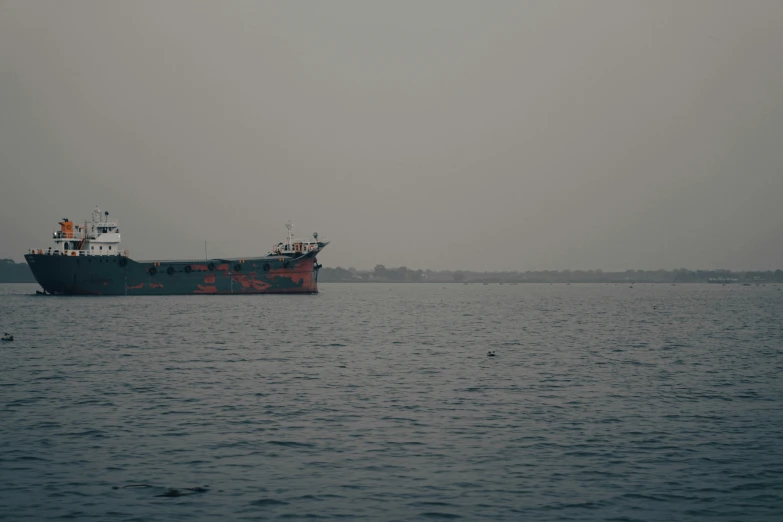 two boats out on the water with a foggy sky in the background