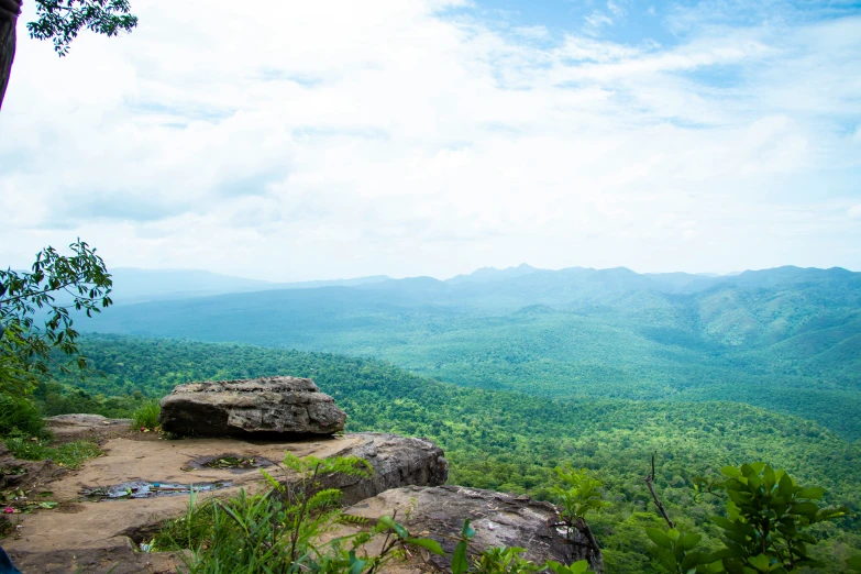 a stone bench overlooks mountains and a valley