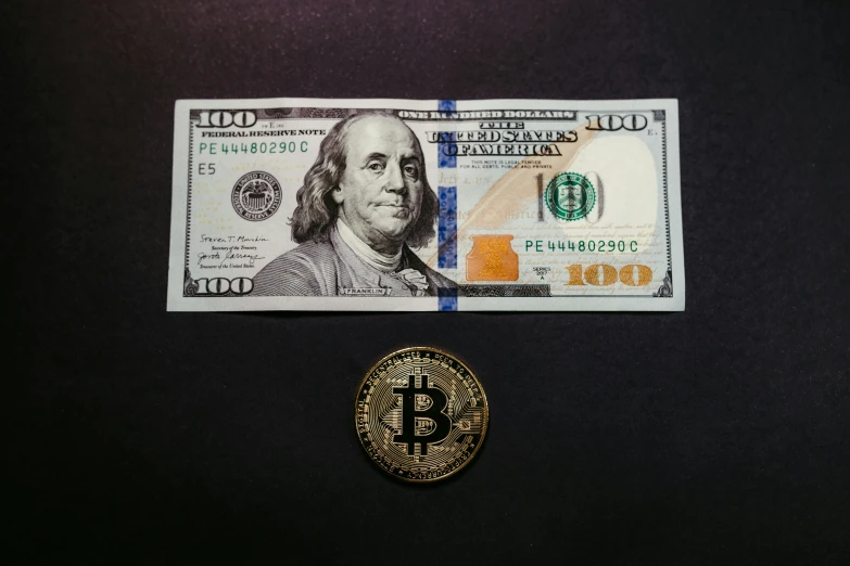 dollar bill laying on top of a bit coin