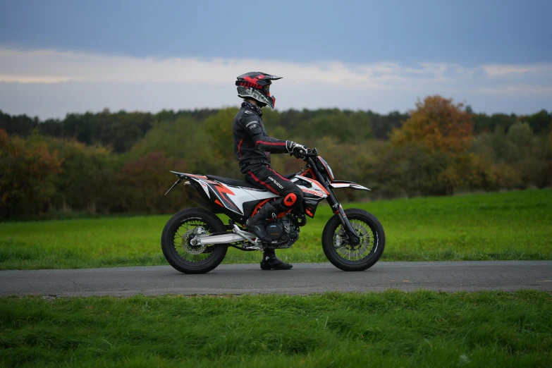 a guy riding his motorcycle in a grassy field