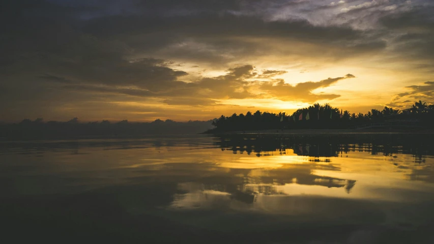 a yellow and red sky hangs over water