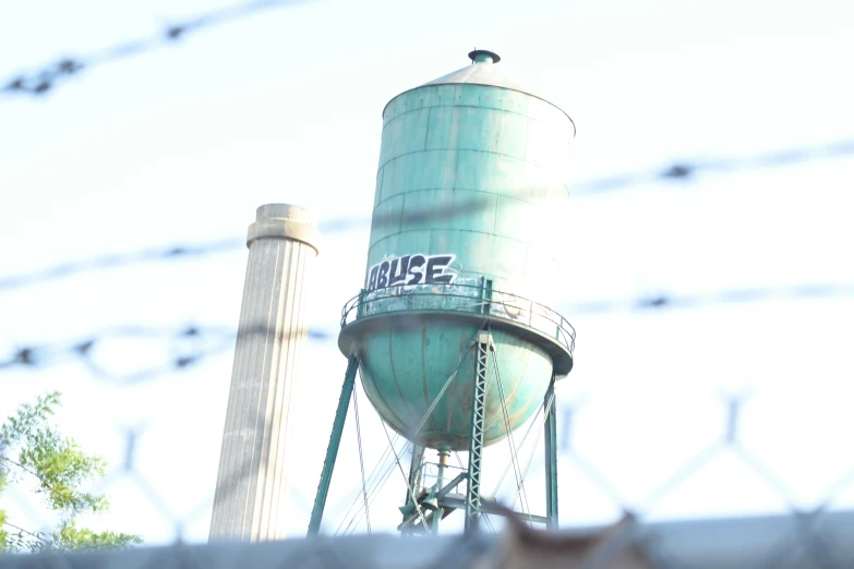 a large blue water tank sitting next to a tall pole