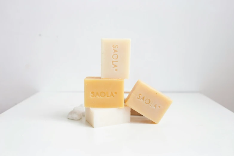 three soap blocks on a white surface with their words soap on them