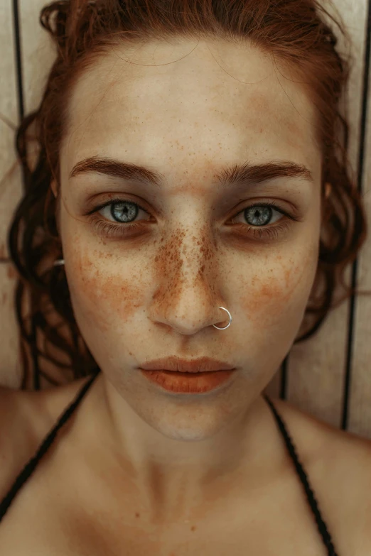 a woman with freckles on her face looking into the camera