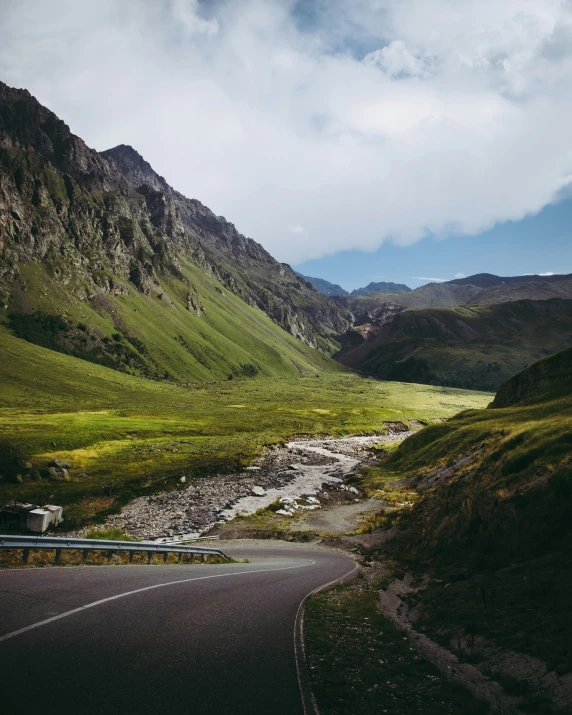 a narrow road winding next to the mountains