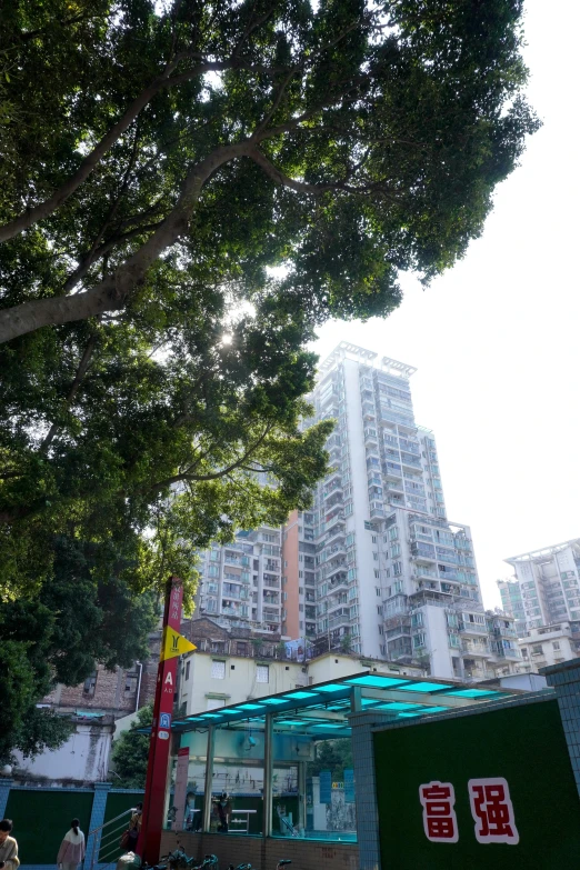 a bus with chinese writing on the front is parked in a street in front of tall buildings