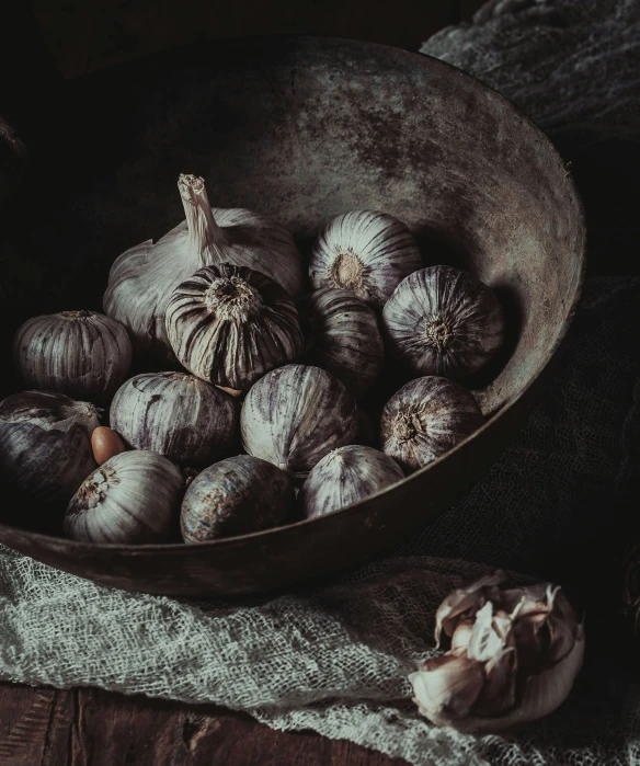 a bowl with a bunch of garlic sitting next to another bowl