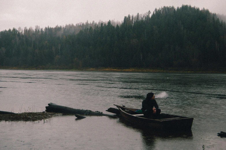 a person sitting in a small boat on the river