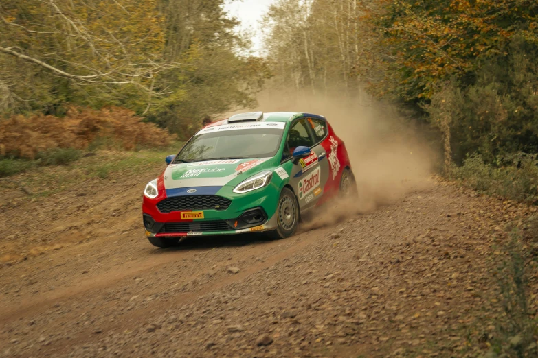 a green car drives on a dirt road