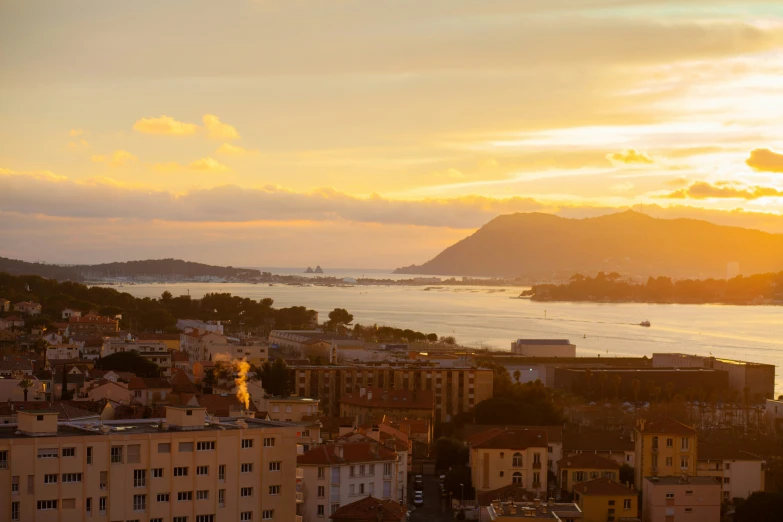 an orange sky is over a city and bay