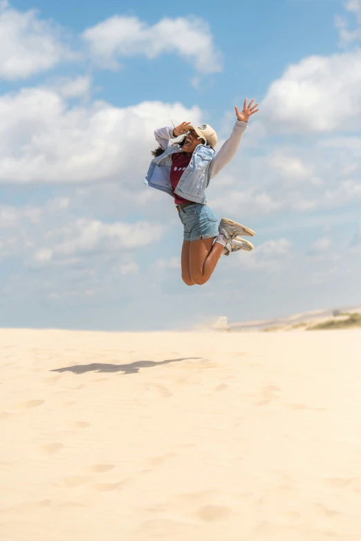 woman jumping in the air with her hand out to catch a frisbee