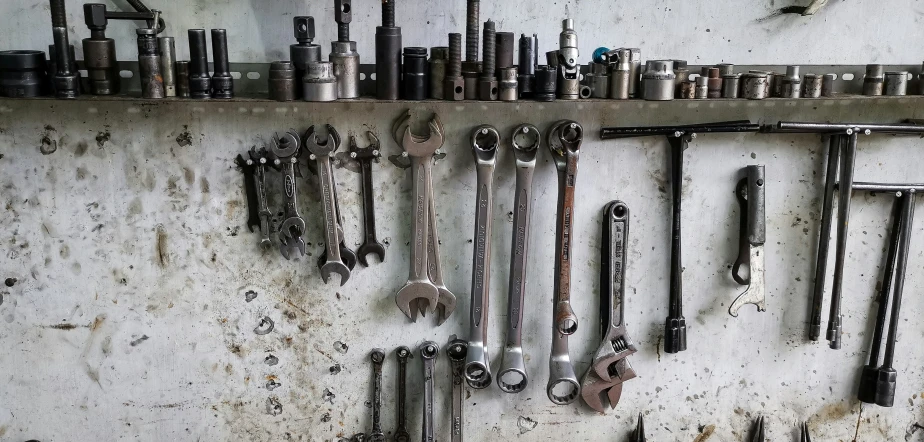 several different kinds of metal wrenches hanging from a wall