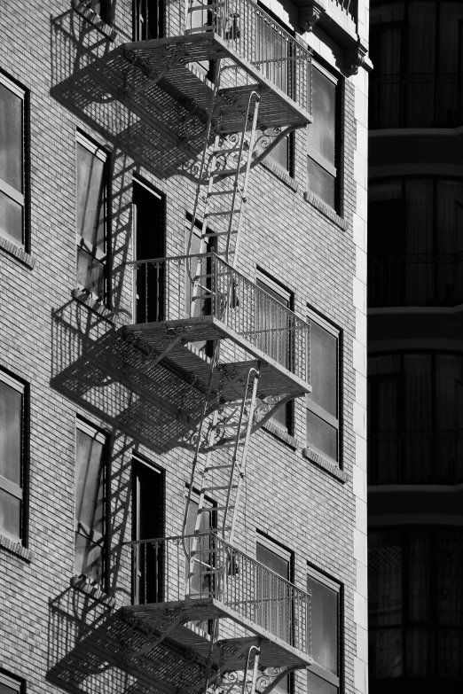 several windows and metal stairs on a brick building