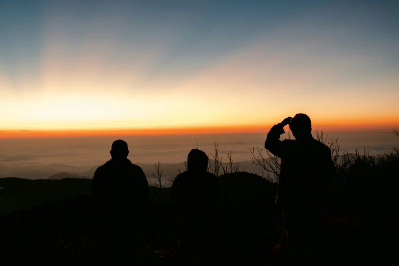 two men looking into the distance with the sun in the background