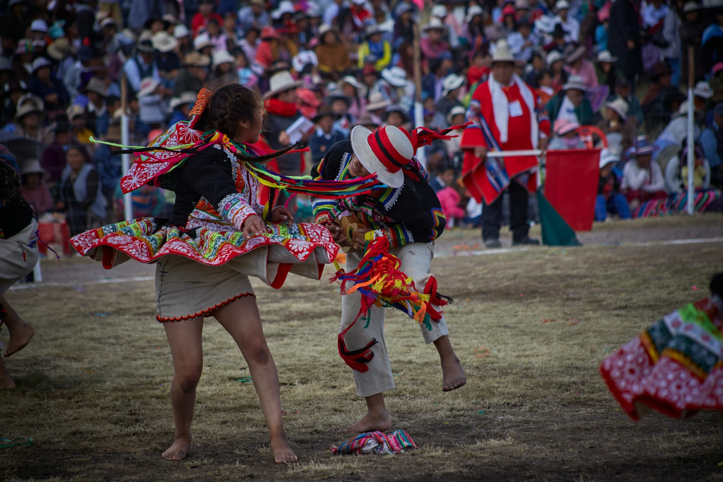 two women in colorful clothing walking on grass with flags