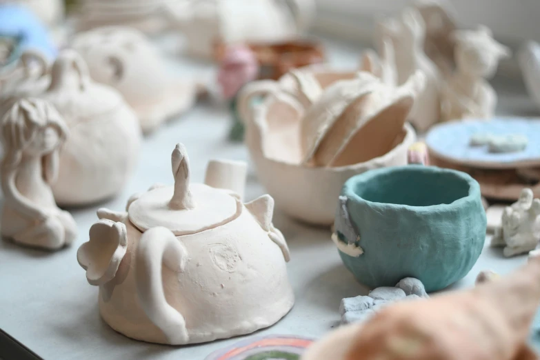 small tea kettles on a table with other ceramics