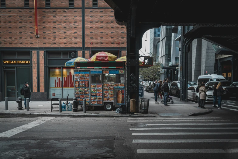 people are walking down the street outside a food cart