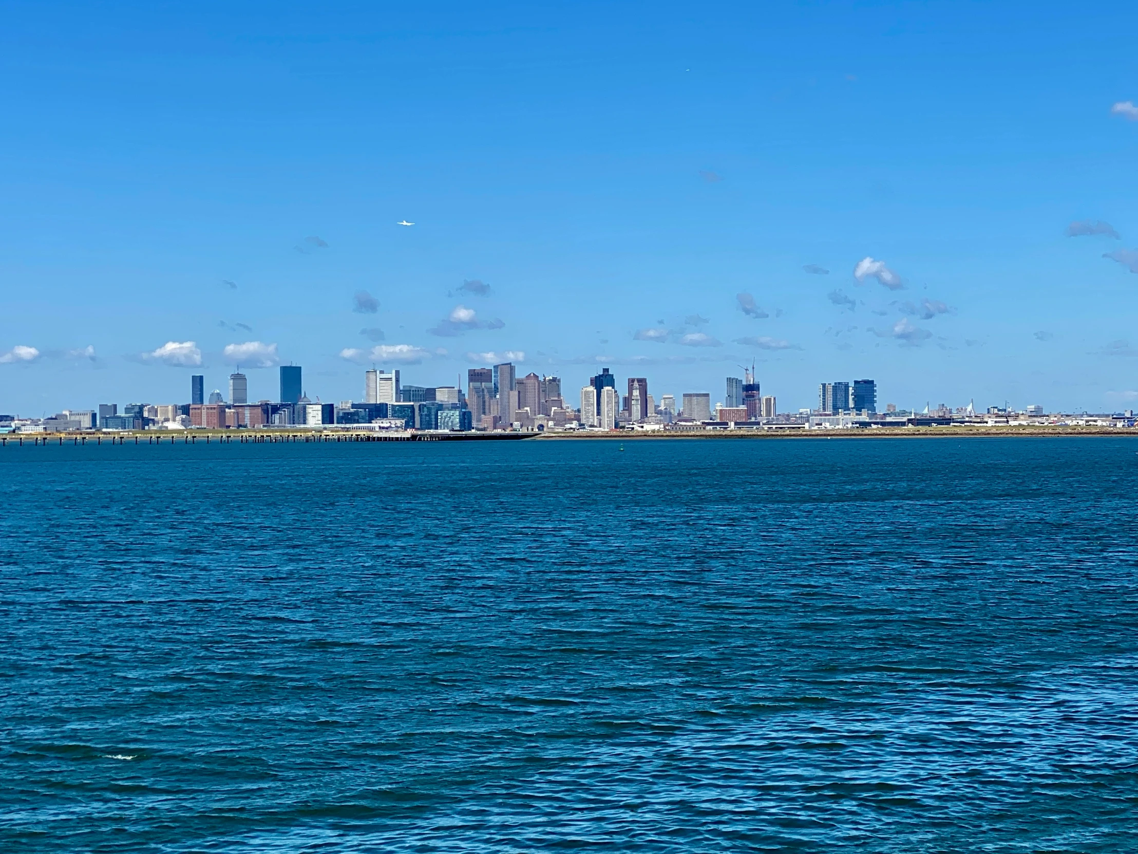 view from a boat on the ocean of a city and blue water