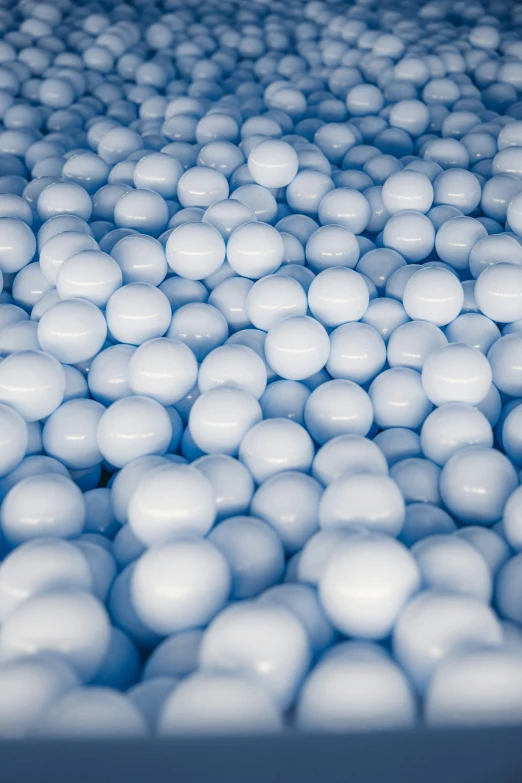 a large amount of white balls sit on a blue background