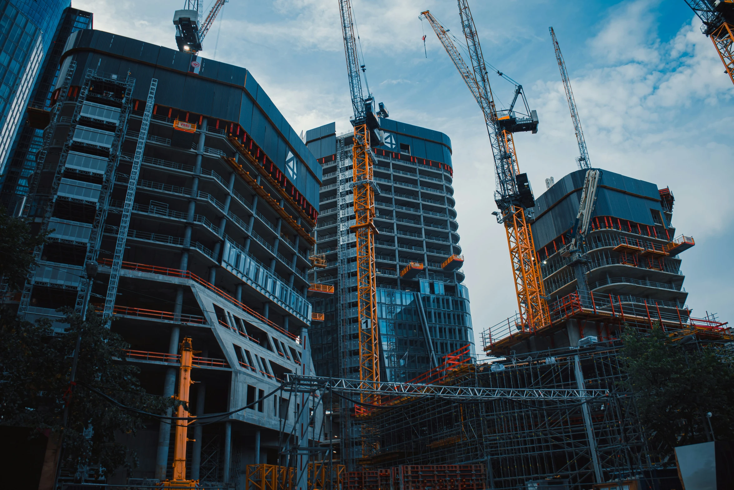 a group of building cranes standing in the sky